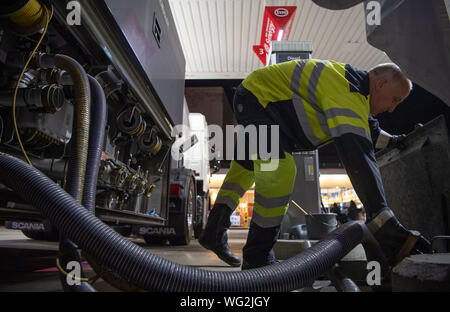 Augsburg, Deutschland. 26 Aug, 2019. Manfred Börner, Tanker, LKW-Fahrer, verbindet Schläuche für die Versorgung mit Kraftstoff zu füllen des Systems der Tankstelle. Einige Tankstellen sind noch offen nach den normalen Geschäftszeiten. (Dpa: "18 Jahre Tankstelle Nachtschicht - und kein Ende in Sicht") Credit: Lino Mirgeler/dpa/Alamy leben Nachrichten Stockfoto