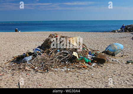 Schutt, Müll oder Müll an einem Strand in Numana in der Nähe von Ancona an der Adria mit Treibholz und Plastikflaschen und andere Schadstoffe Stockfoto