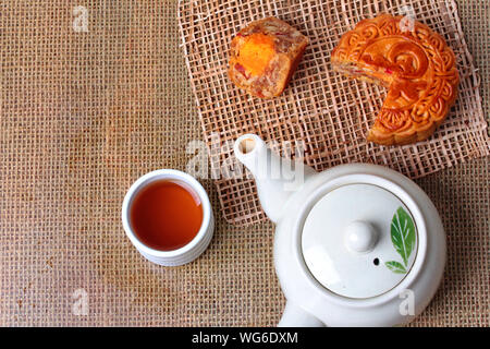 Runde mooncake gefüllt 8 Körner und gesalzenen Eier mit Kaffee und Teekanne serviert. Stockfoto