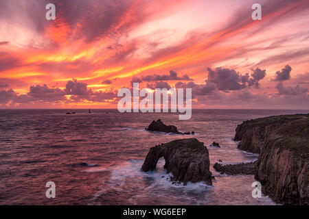 Lands End Cornwal Sonnenuntergang am Lands End Cornwall mit Enys Dodnan Arch und Langschiff Leuchtturm, Lands End Cornwall auf dem Cornish Coastal Walk Stockfoto