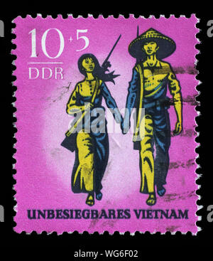 Stempel ausgestellt in Deutschland - Demokratische Republik (DDR) zeigt ein Paar mit Waffen unbesiegbar Vietnam, circa 1969. Stockfoto