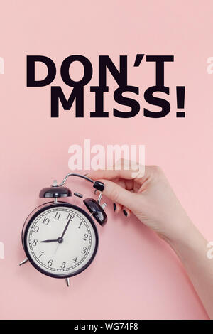 Kreative flach Slogan nicht Konzept vermissen, oben Frau hand Schwarz Vintage Wecker Pastell tausendjährigen rosa Papier Hintergrund in Minima Stockfoto