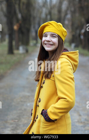 Schönes junges Mädchen in einem gelben Fell und Baskenmütze Porträt Herbst Stockfoto