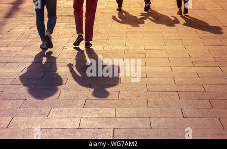 Schatten und Silhouetten von Menschen, die Stadt bei Sonnenuntergang, Menschen zu Fuß auf einer Straße Stockfoto