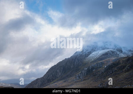 Atemberaubende Moody dramatische Winterlandschaft Bild von schneebedeckten Tryfan Berg in Snowdonia bei stürmischem Wetter Stockfoto