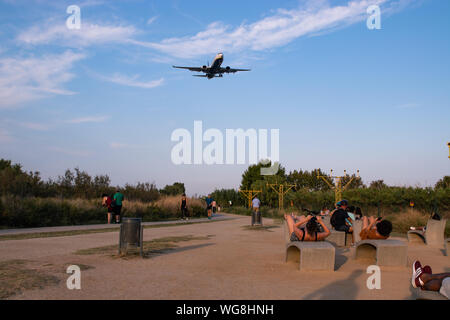 Barcelona, Spanien - 30. August 2019: Leute beobachten und die Bilder von einem Flugzeug landen von der Startbahn Sicht der Flughafen Barcelona El Prat Stockfoto