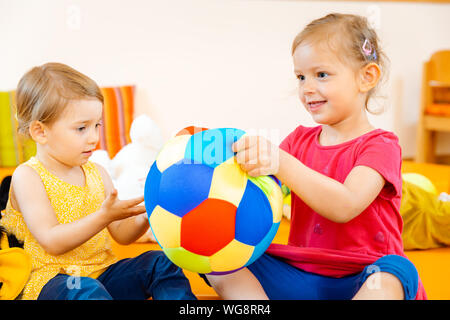 Zwei Mädchen in Schule Spiel Spaß mit einer Kugel Stockfoto