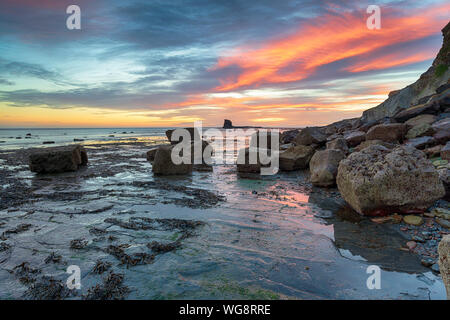 Atemberaubender dramatischer Sonnenaufgang über roacks an Saltwick Bay in der Nähe von Whitby an der Küste von North Yorkshire Stockfoto