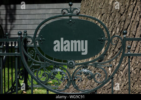 Leer leer Zeichen auf Metall schmieden Zaun vor der großen Baum. Mock up von Informationen Tabelle Plakat text der Symbole hinzuzufügen. Repräsentant in der Park- oder Bo Stockfoto