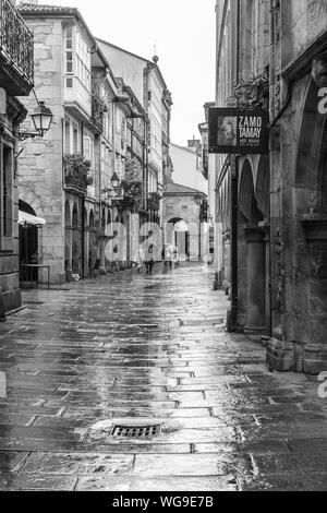 Santiago de Compostela, Spanien; August 9, 2019: Straße der Altstadt von Santiago de Compostela an regnerischen Tag. Die Schwarz-Weiß-Fotografie Stockfoto