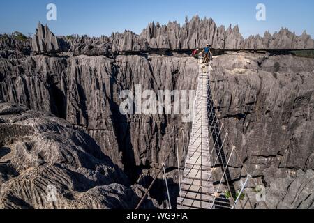 Touristische auf der Hängebrücke über die Schlucht in den schroffen Kalkfelsen, Kalksteinfelsen in der Tsingy de Bemaraha Nationalpark, Madagaskar Stockfoto