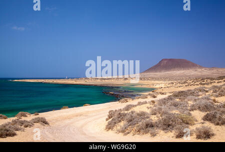 Insel La Graciosa, Teil der Chinijo Archipel, in der Nähe von Lanzarote, Blick Richtung Montana Amarilla, Yellow Mountain, in flachen Gewässern von Bahia del Stockfoto