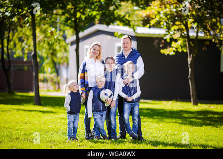 Happy Family im Freien. Happy kaukasischen Familie, die außerhalb ihres Hauses und umarmen. Familie mit vier Kindern vor Haus. Große, glückliche Familie Stockfoto