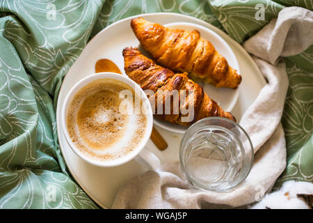 Morgen Frühstück mit Kaffee und Croissants im Bett. Ansicht von oben Stockfoto