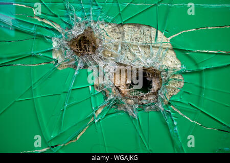 In der Nähe von zwei Einschusslöcher in grün gefärbten Fenster Glas Stockfoto