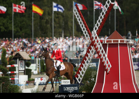 01. September 2019, Niedersachsen, Luhmühlen: Pferdesport, Eventing, Europäische Meisterschaft: Eine eventing Reiter kann hinter einem Sprung in der Form einer Windmühle gesehen werden. Foto: Friso Gentsch/dpa Stockfoto