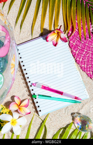 Leere Schreiben von Notizen mit rosa und grünen Stift auf Sand Öffnen, durch grüne Palme treibt, Muscheln, rosa Hut umgeben, aufblasbare Spielzeuge. Sommer Strand hinterg Stockfoto