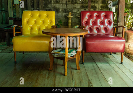 Gelbes Sofa und roten Sofa auf dem Holzboden auf Terrasse. Stockfoto