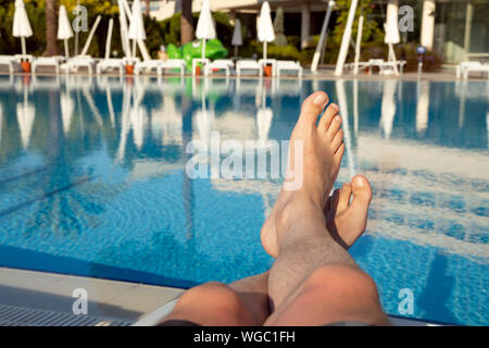 Männer die Füße auf dem Hintergrund der Swimmingpool, im Urlaub entspannen Stockfoto