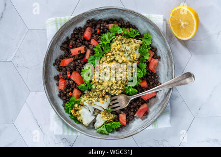 Pesto - verkrusteten Kabeljau mit Puy Linsen und Tomaten - Ansicht von oben Stockfoto