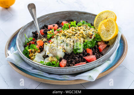 Pesto - verkrusteten Kabeljau mit Puy Linsen und Tomaten in eine Schüssel geben. Stockfoto