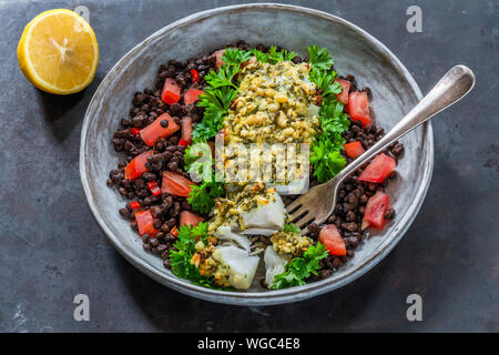 Pesto - verkrusteten Kabeljau mit Puy Linsen und Tomaten - Hohe Betrachtungswinkel Stockfoto