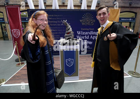 Engel Greech und George Wells von der Schwimmenden Hut Installation, die bevorstehende Veröffentlichung der neuen Zauberwelt App in London Kings Cross Station feiert, als Harry Potter Fans gesammelt, um zu sehen, wie sich die Hogwarts Express auf der Abfahrt an King's Cross in London während Zurück nach Hogwarts Tag erscheint. Stockfoto