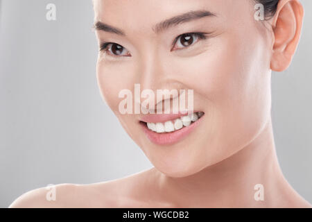 Asiatische Schönheit. Junge Frau isoliert auf Weiss. Ansicht von der Seite Stockfoto