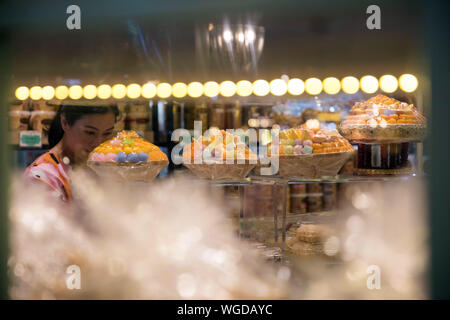 Bangkok, Thailand. 1. Sep 2019. Ein Kunde wählt die traditionelle thailändische Desserts im Gebäck store in Bangkok, Thailand, Sept. 1, 2019. Tanga Yip, Tanga Yod und Foi Tanga sind drei traditionelle thailändische Desserts für wichtige Anlässe und Zeremonien. Die Farben dieser Desserts, Gelb oder Gold, steht für Gunst und Reichtum in die thailändische Kultur. Von Eigelb, Sirup und Mehl, das süße Desserts sind beliebt bei Einheimischen. Credit: Zhang Keren/Xinhua/Alamy leben Nachrichten Stockfoto