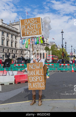 Der Demonstrant mit leeren Plastikflaschen Protest gegen die Verwendung von Kunststoffen in der Parliament Street, Westminster, London, Großbritannien. Stockfoto