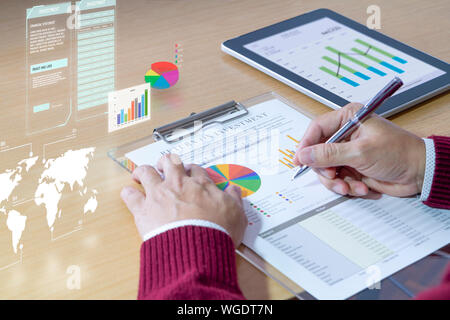 Geschäftsmann mit virtueller Realität Grafiken ist zutiefst Überprüfung einer finanziellen Bericht für einen Return on Investment, ROI, oder Investitionen Risikoanalyse. Stockfoto