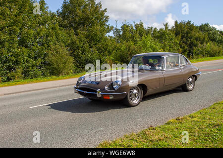 1960 60er Jahre brauner Jaguar E-Typ fährt in der 2019 Bradford nach Morecambe Charity Oldtimer-Rallye, alt, Retro-Fahrzeug, historisches Automobil, Transport, Classic antique, Sammlung, Autotransport, Design, Motor, Fahren, historisch, Geschichte, Show, Motor, Restauriertes Sammlerstück, Stil, historische Fahrzeug laufen. Stockfoto