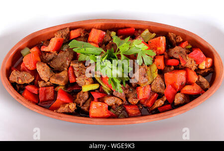 Türkische wurst Paprika Tomaten und grünen in einem Tontopf und eine weiße Platte Stockfoto