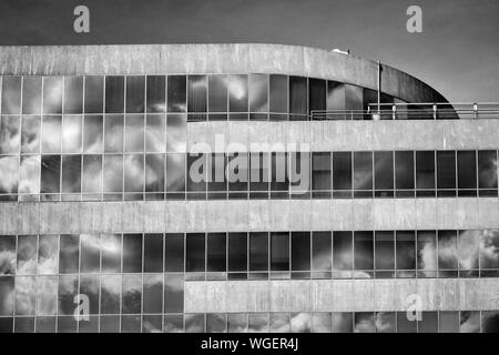 Ein Gitter aus Fenstern reflektiert Wolken in diesem modernistischen Gebäude, das von I. M. Pei in der Innenstadt von Asheville, NC, USA, entworfen wurde. Stockfoto