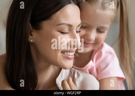 Closeup Portrait liebevolle Tochter kuscheln junge Mutter Stockfoto