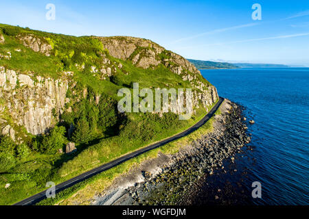 Nordirland, Großbritannien. Die Antrim Coast Road alias Causeway Coastal Route in der Nähe von Ballygalley Kopf und Resort. Eine der schönsten Küstenstraßen Europas. Stockfoto