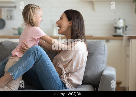 Urkomisch Mutter Holding Tochter von Taille haben gemeinsam Spaß im Innenbereich Stockfoto