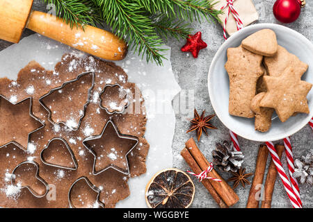 Weihnachten Lebkuchen cookies mit Fir Tree Branches, Geschenkboxen und Dekorationen auf grauem Beton Hintergrund. top anzeigen. Flach Stockfoto