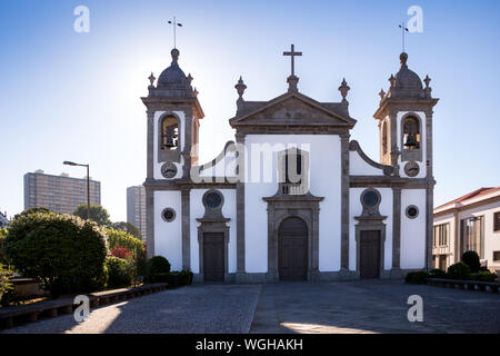 Kirche Igreja Paroquial de Leca da Palmeira. Weiße Fassade und dunklen Details. Zwei Tower, Kreuz über dem Eingang. Blue Sky. Palmeira, Portugal. Stockfoto