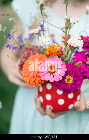 Mädchen, dass eine schöne helle Strauß Wildblumen in Ihren Händen Stockfoto