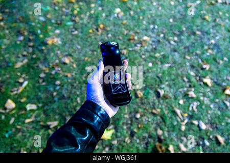 Hand mit einem bat-Detektor auf eine Fledermaus Spaziergang im Park, London, UK Stockfoto