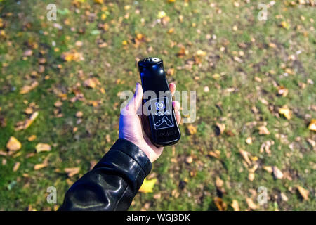 Hand mit einem bat-Detektor auf eine Fledermaus Spaziergang im Park, London, UK Stockfoto