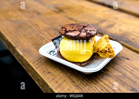Brownie Cookie Sandwich mit vegan Mango Lassi Eis und wabe an Chin Chin Labs, Camden Market, London, UK Stockfoto