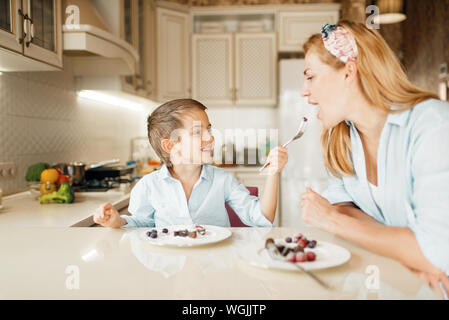 Mutter mit Kind Verkostung Dessert und Spaß Stockfoto