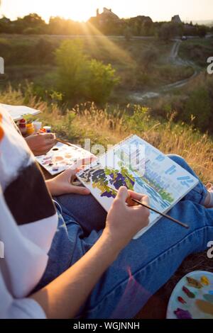 Zeit der Kreativität. Malen en Plein Air. Mädchen zieht eine Landschaft in der Natur Stockfoto