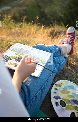 Zeit der Kreativität. Malen en Plein Air. Mädchen zieht eine Landschaft in der Natur Stockfoto