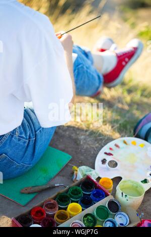 Zeit der Kreativität. Malen en Plein Air. Mädchen zieht eine Landschaft in der Natur Stockfoto