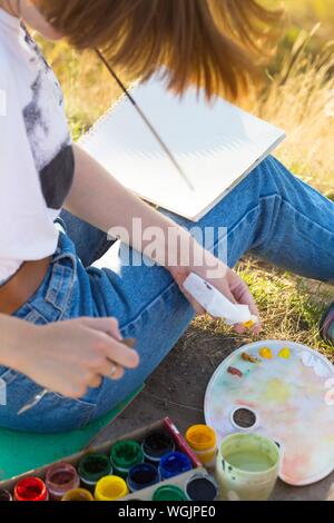 Zeit der Kreativität. Malen en Plein Air. Mädchen zieht eine Landschaft in der Natur Stockfoto