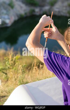 Zeit der Kreativität. Malen en Plein Air. Mädchen zieht eine Landschaft in der Natur Stockfoto