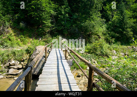 Holzbrücke über Mountain River. Stockfoto